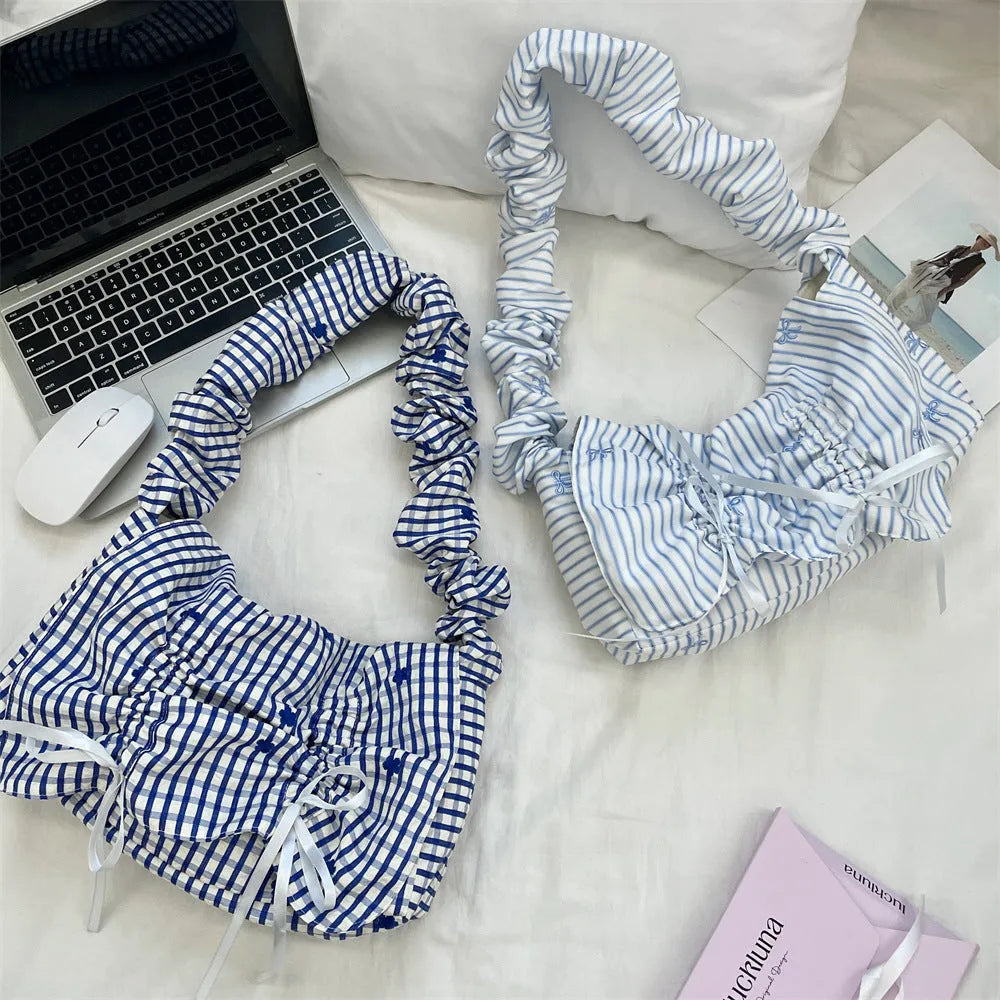 Women's polyester pleated shoulder bag with blue plaid pattern and blue bow detail, clamshell opening