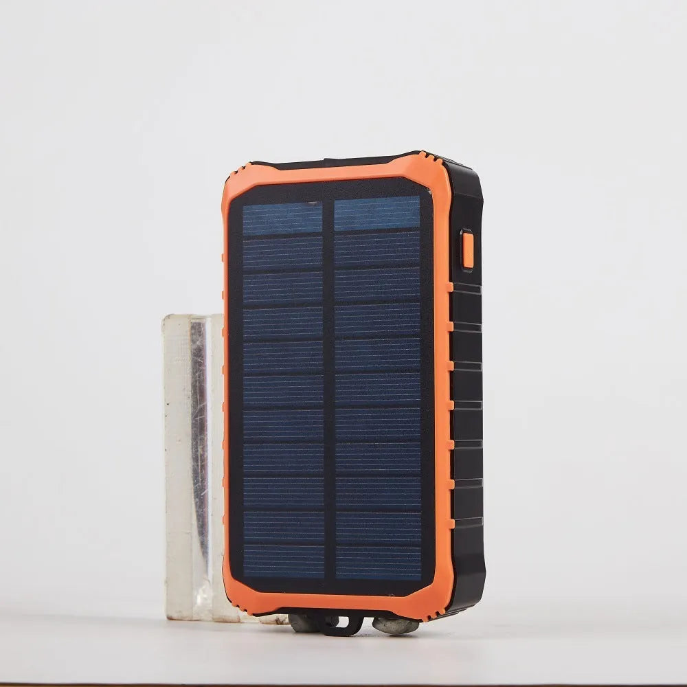 Orange portable solar power bank with hand crank and dual USB ports