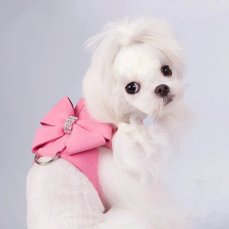 A pink microfiber dog chest strap with a large decorative bowknot and metal buckle.