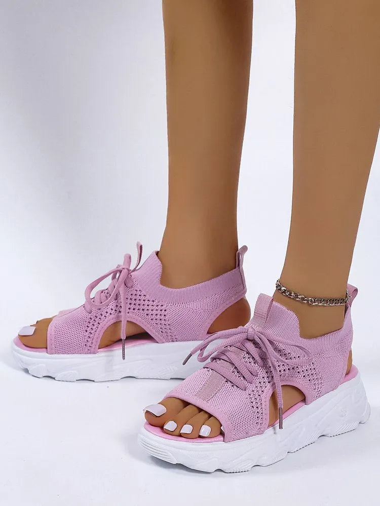 Lace-up sandals for women with thick rubber sole and mesh upper in orange colour, flat design