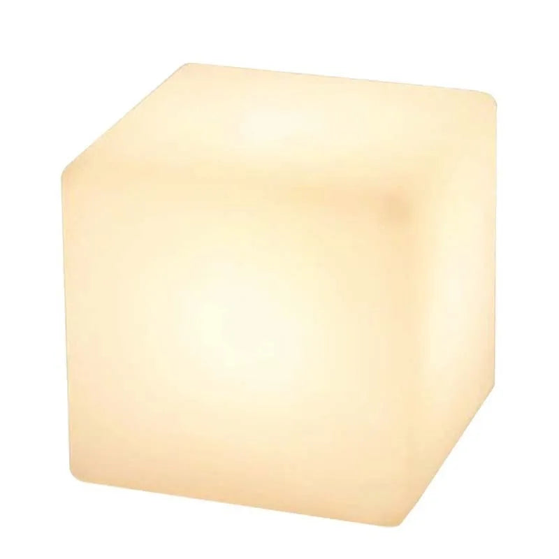 A modern, square white LED cube light functioning as a waterproof outdoor stool.
