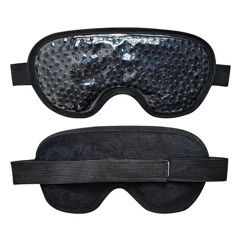 White rechargeable hot and cold compress eye massager device with included eye mask and charging cable on a plain background.