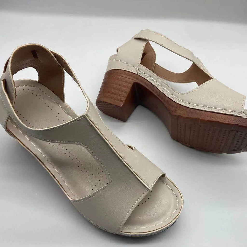 Womens beige Roman style wedge sandals with open peep toe and silver buckle strap on a low heel.