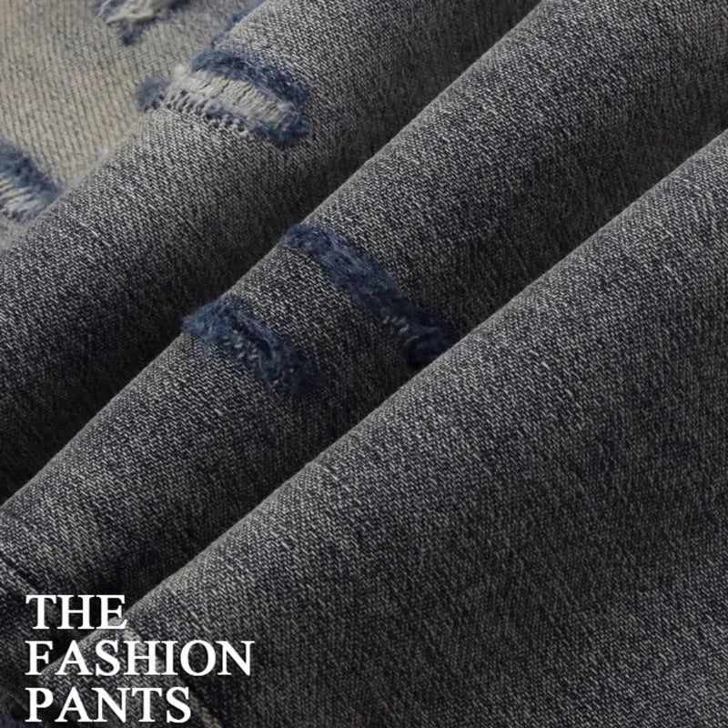 Men's slim fit vintage jeans with a washed-out colour and distressed hole patch embroidery.