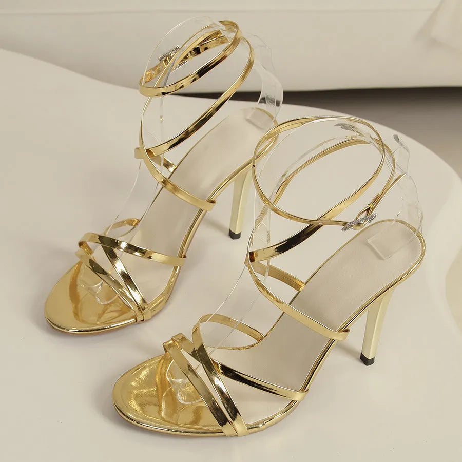 Gold women's stiletto sandals with a buckle fastening on the cross-strap