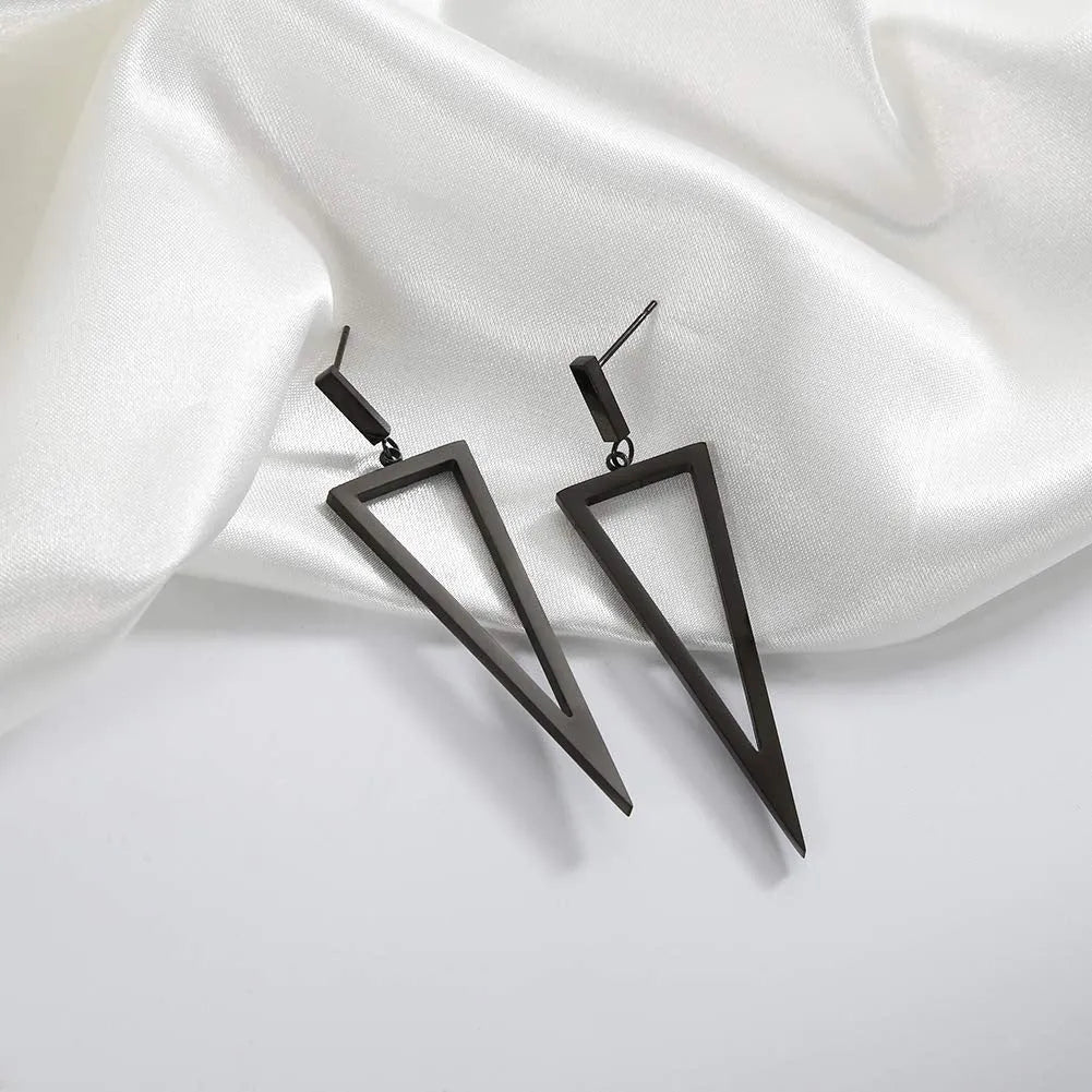 Black metal triangle earrings with electroplated finish on a neutral background