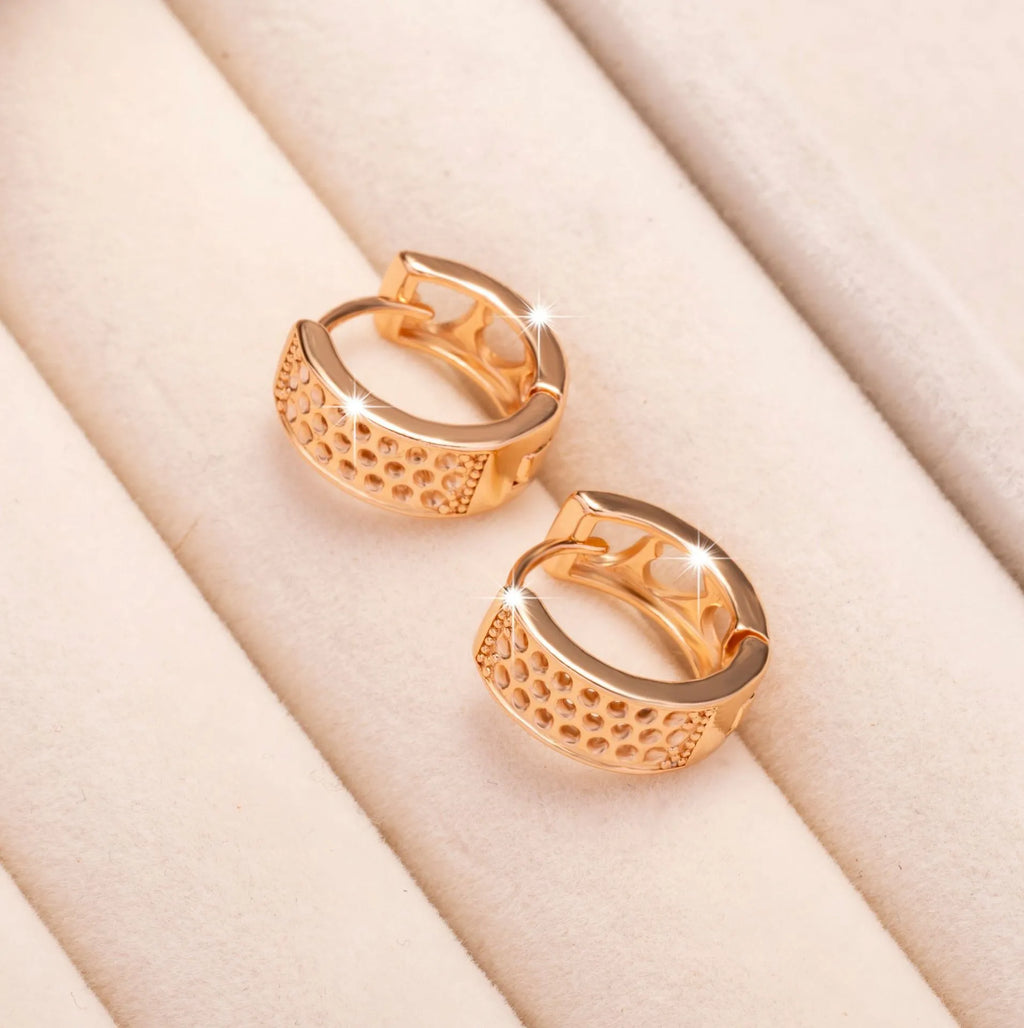 Rose gold hollowed-out stainless steel earrings showing three heart shapes in a circular design.