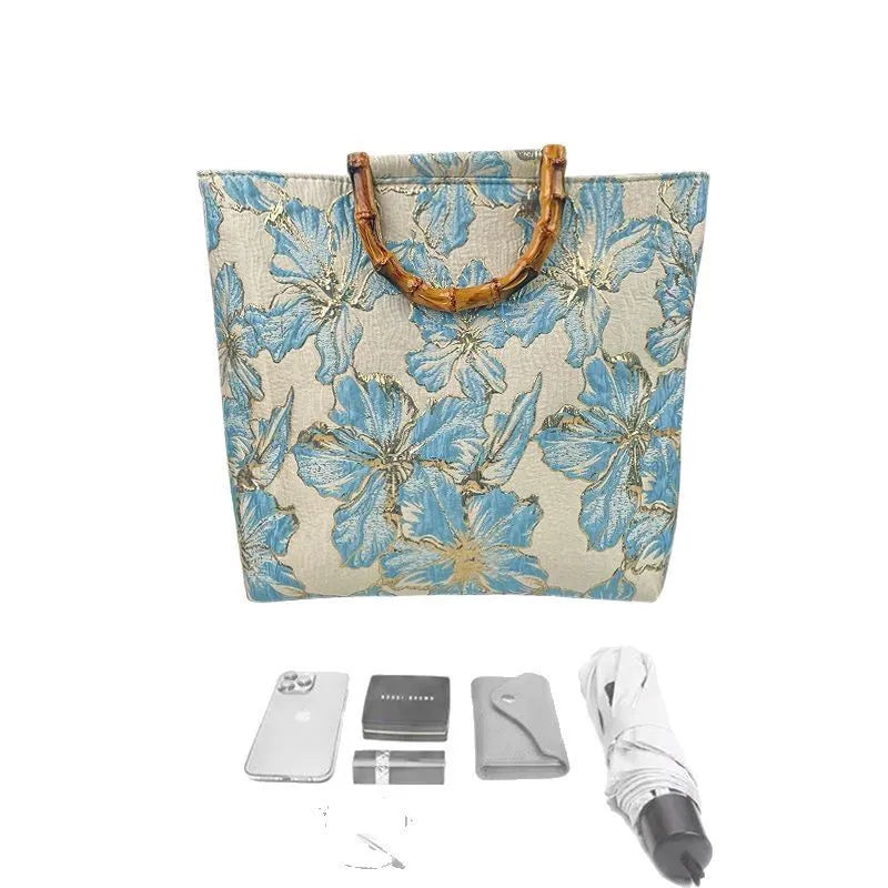 Light blue canvas shoulder bag with bronzing flower print, square shape, and two adjustable connector straps