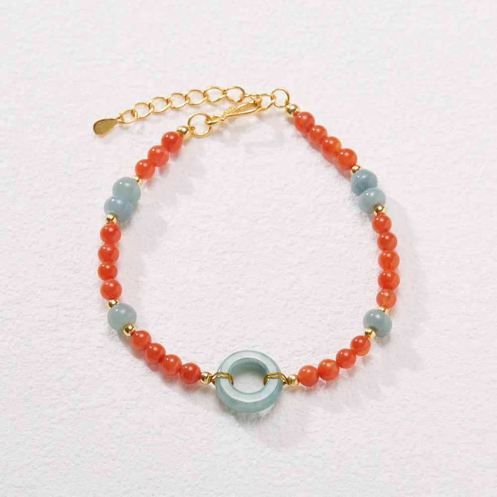 Close-up of a women's south red agate bracelet with geometric beads and a safety buckle clasp on a wrist.