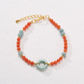 Close-up of a women's south red agate bracelet with geometric beads and a safety buckle clasp on a wrist.