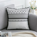 Bohemian national style throw pillow cushion cover in light grey on a sofa.