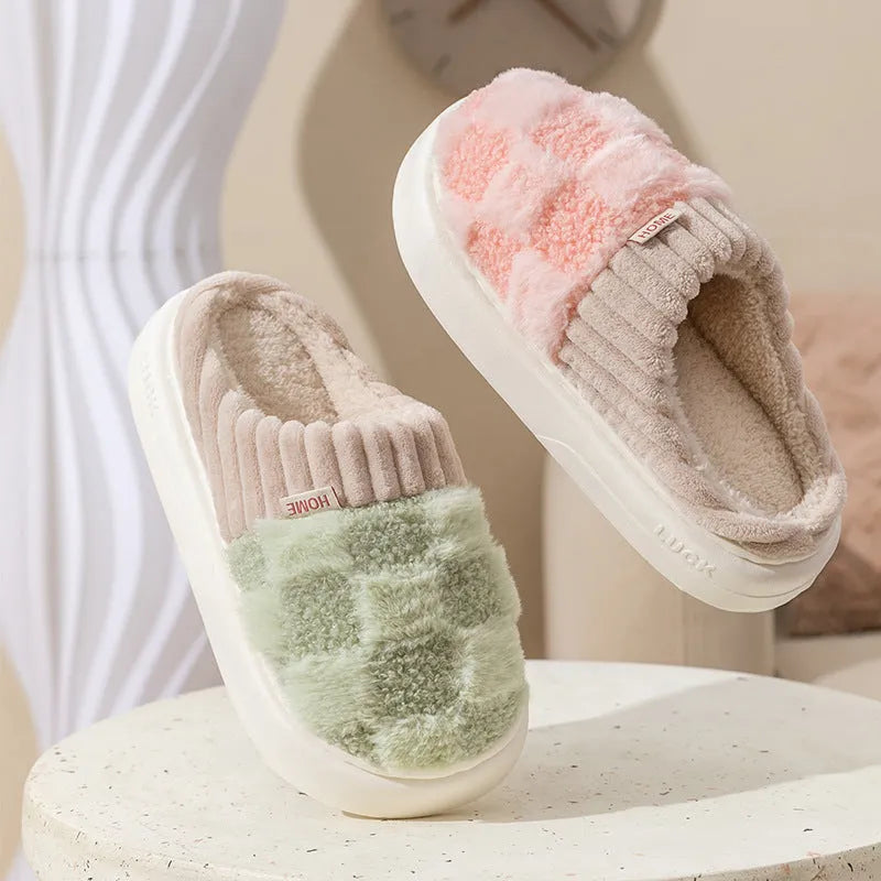 Plaid pattern women's plush slippers with round toe and flat heel on a coloured background.