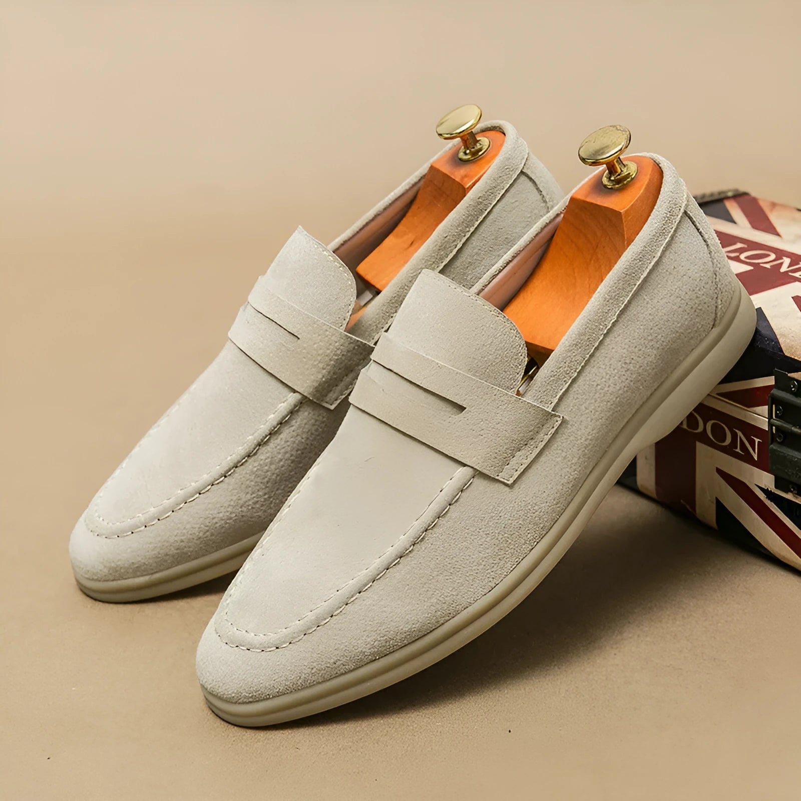 Men's beige leather slip-on casual shoes with round toe and rubber sole on a white background.