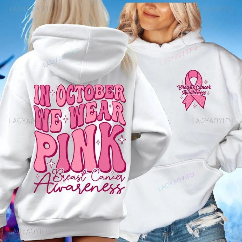 Pink breast cancer awareness hoodie with retro pattern and side pocket on a hanger.