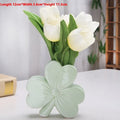 White porcelain clover-shaped ceramic vase in European style, on a desktop.