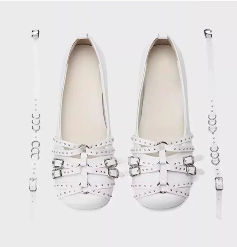 Women's black patent leather retro pumps with a buckle and low flat heel on a white background.