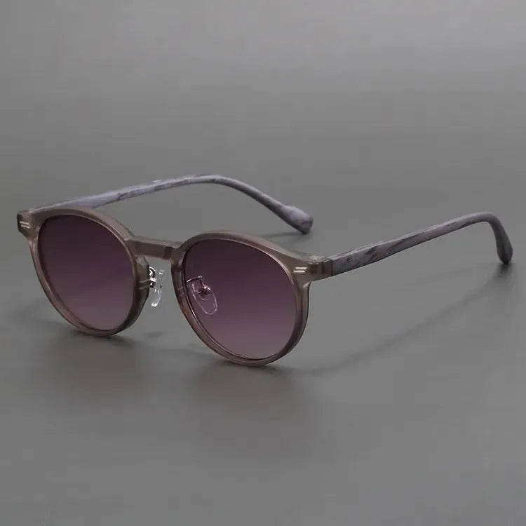 Retro round frosted sunglasses in leopard print and sand colours on a patterned background.