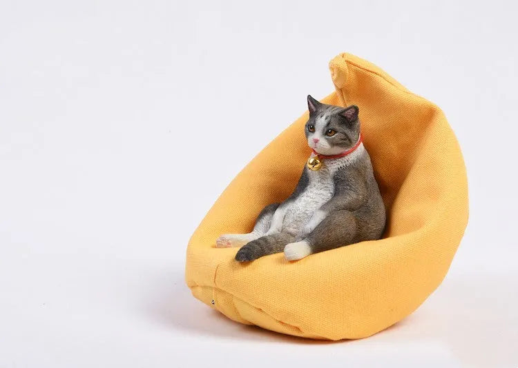 Resin lazy cat car ornament with fabric sofa, approximately 7.5cm high.