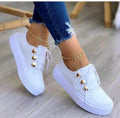Women's white lace-up flats sneakers with round toe and decorative silver rivet details on the artificial PU upper.