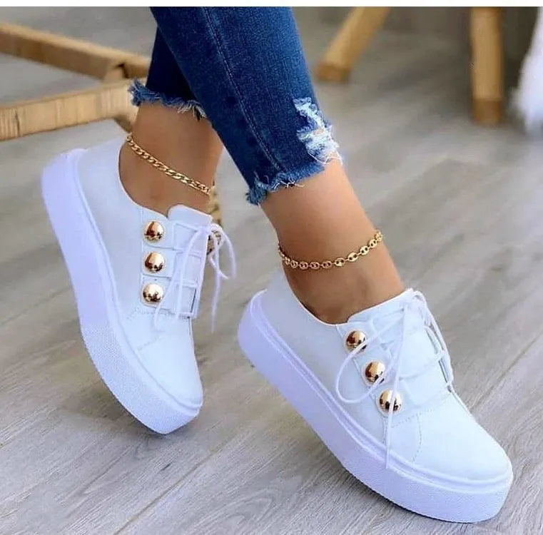 Women's white lace-up flats sneakers with round toe and decorative silver rivet details on the artificial PU upper.