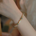 Simple women's bracelet made of round white Hetian jade beads on a wrist.