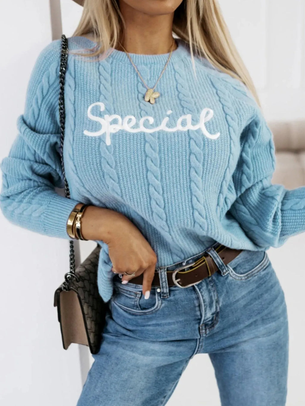 Blue crew neck pullover sweater with embroidered letter and number design on the chest.