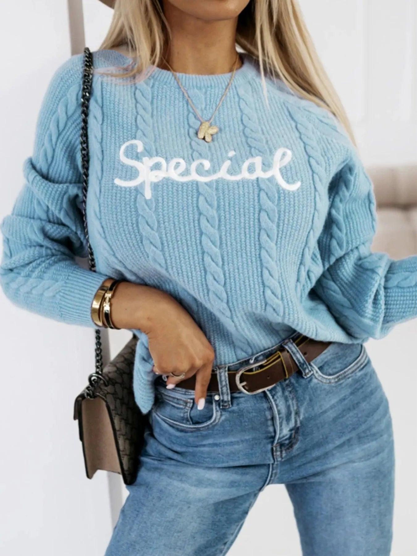 Blue crew neck pullover sweater with embroidered letter and number design on the chest.