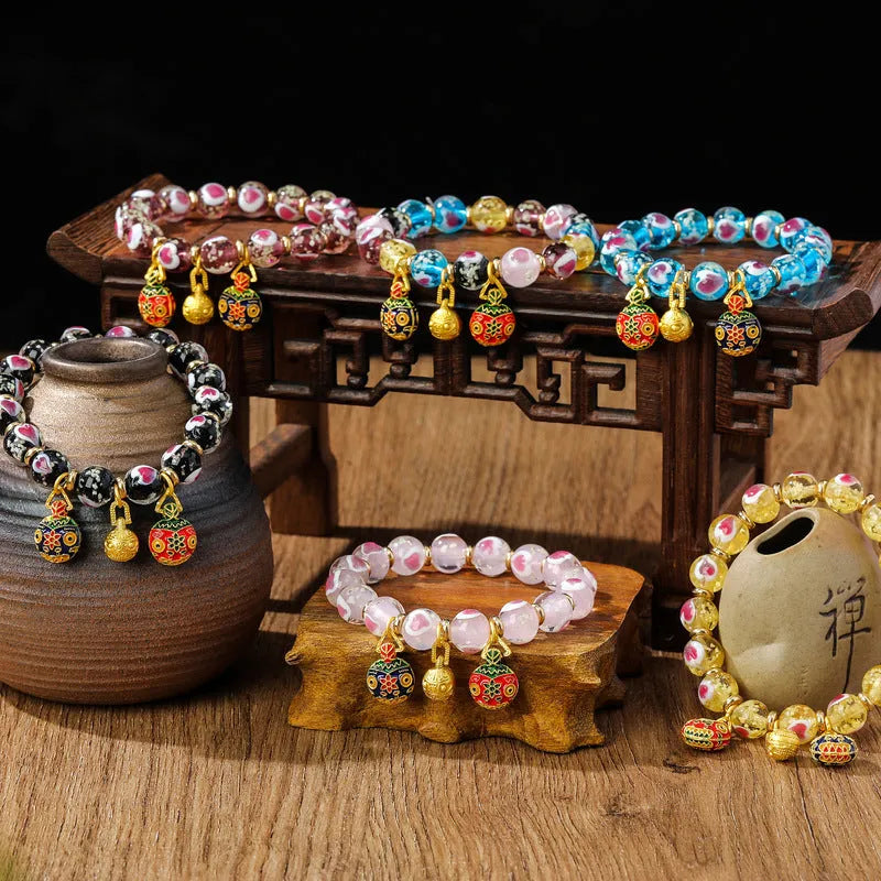 Handmade glass bracelet with swallowing gold beast design and cherry blossom heart in six colours.