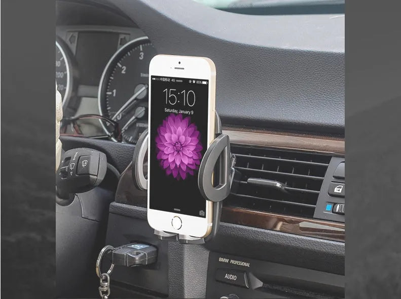 Black plastic car phone holder mounted on air conditioning vent holding smartphone