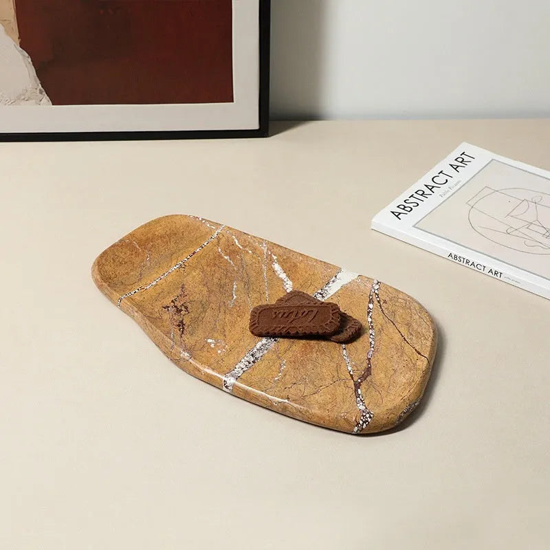 Irregular art marble tray in coffee colour on a wooden table with a plant