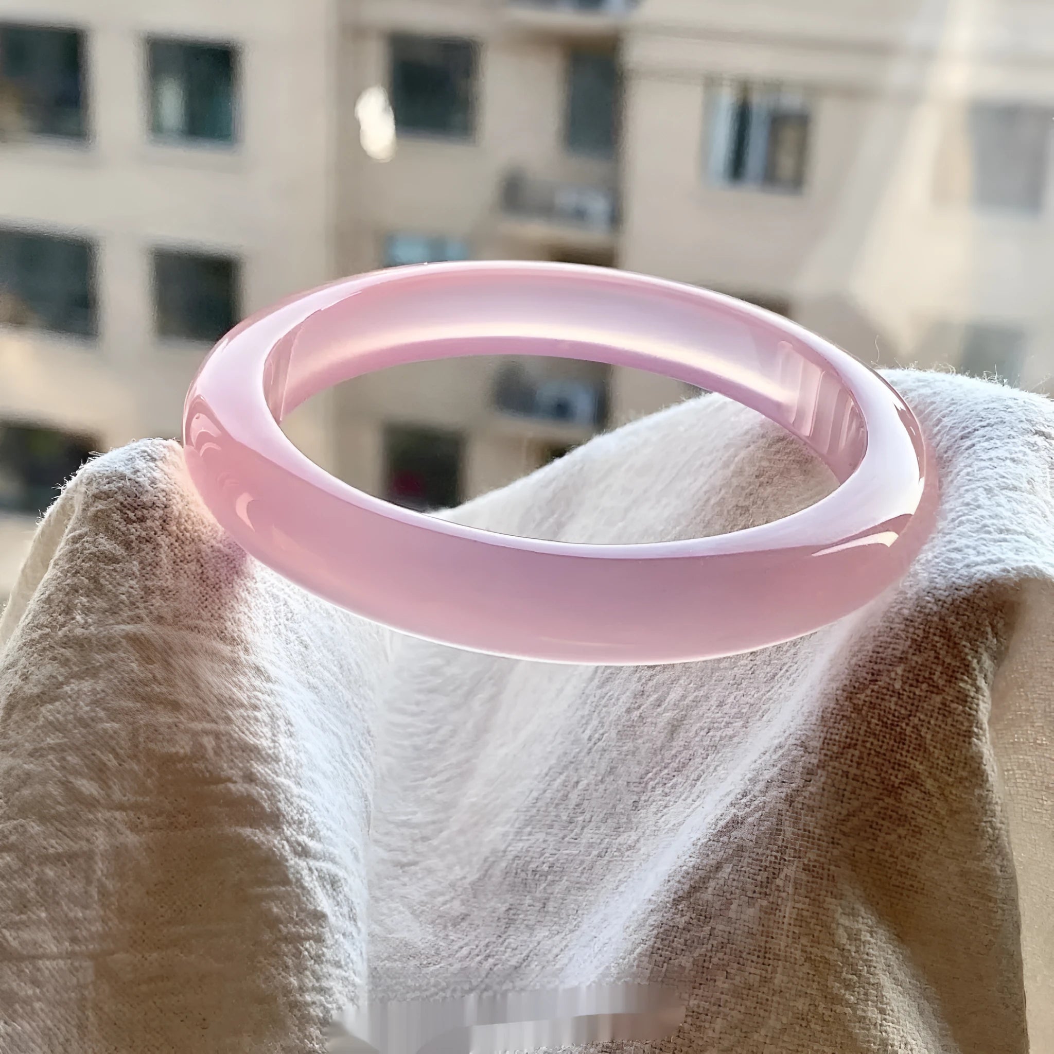 Natural agate wide bead bracelet in pink on a wrist, showing 10mm bead width and smooth stone texture.