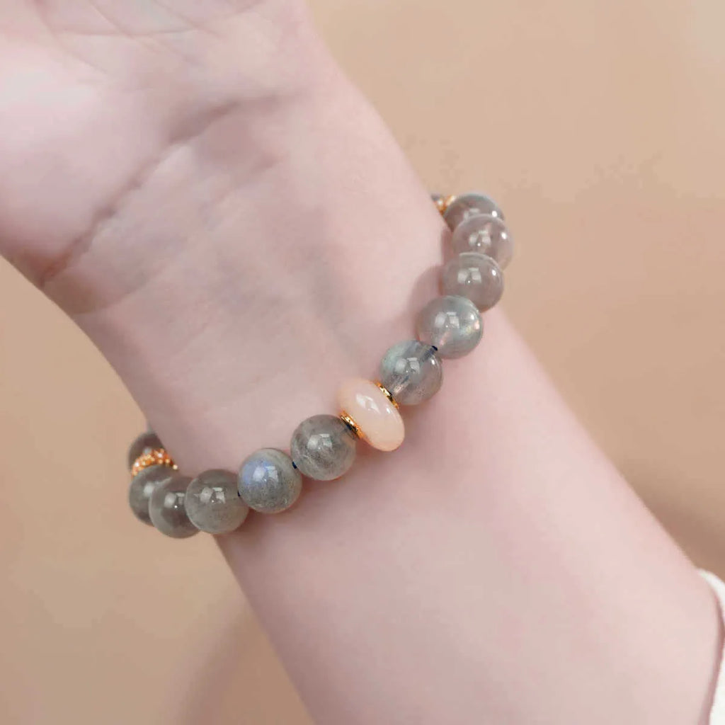Grey moonstone agate half-wrap bracelet with 8mm round beads on a woman's wrist.