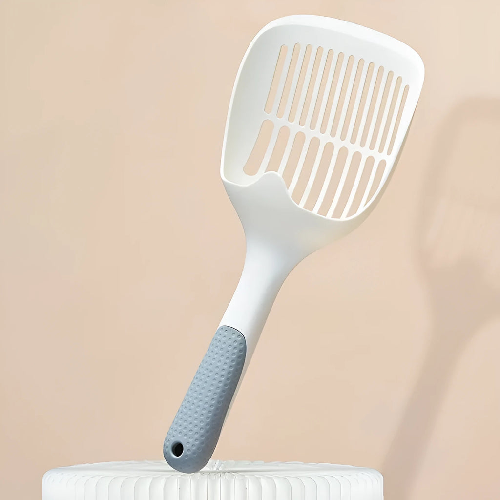 White plastic cat litter scoop with an integrated storage base on a flat surface.