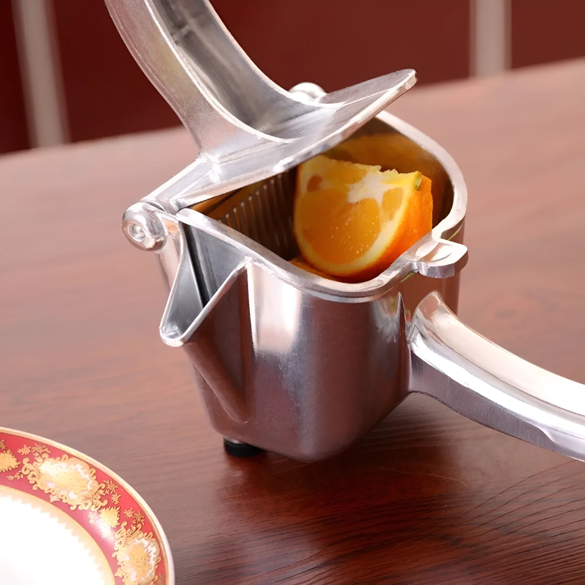 Silver heavy duty aluminium lemon squeezer with large bowl and steel lever on a kitchen counter.