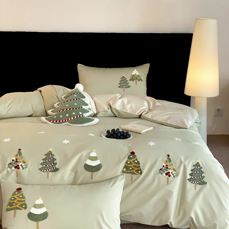 Pure cotton Christmas tree towel embroidery bedding four-piece set in cream blue on a bed.