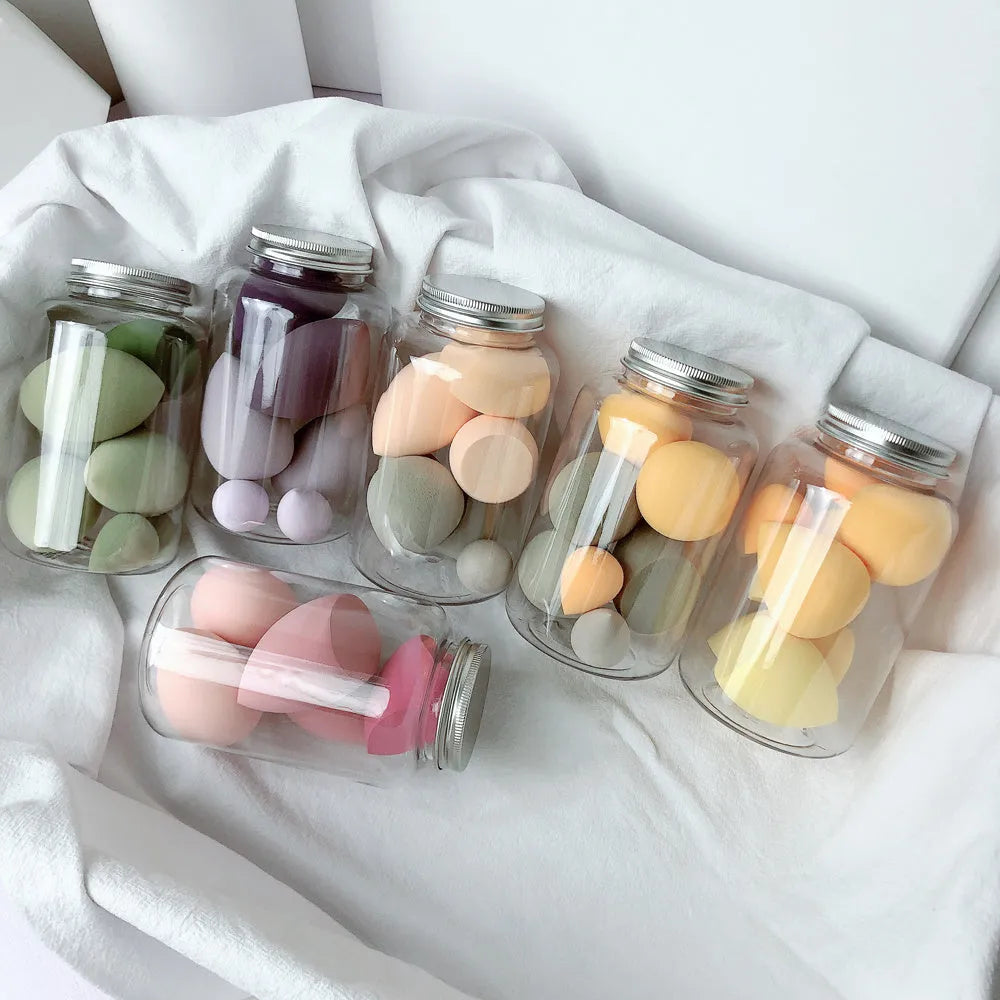 Set of 7 colourful makeup sponge eggs in a transparent jar against a white background