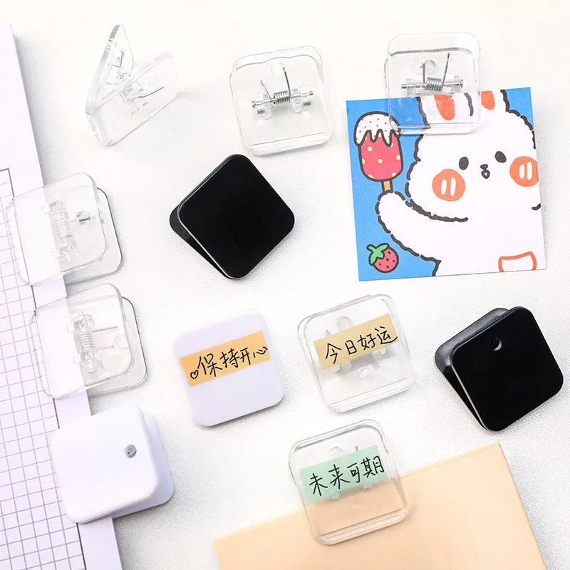 Small square plastic photo note holder in white, black and transparent colours on a desk