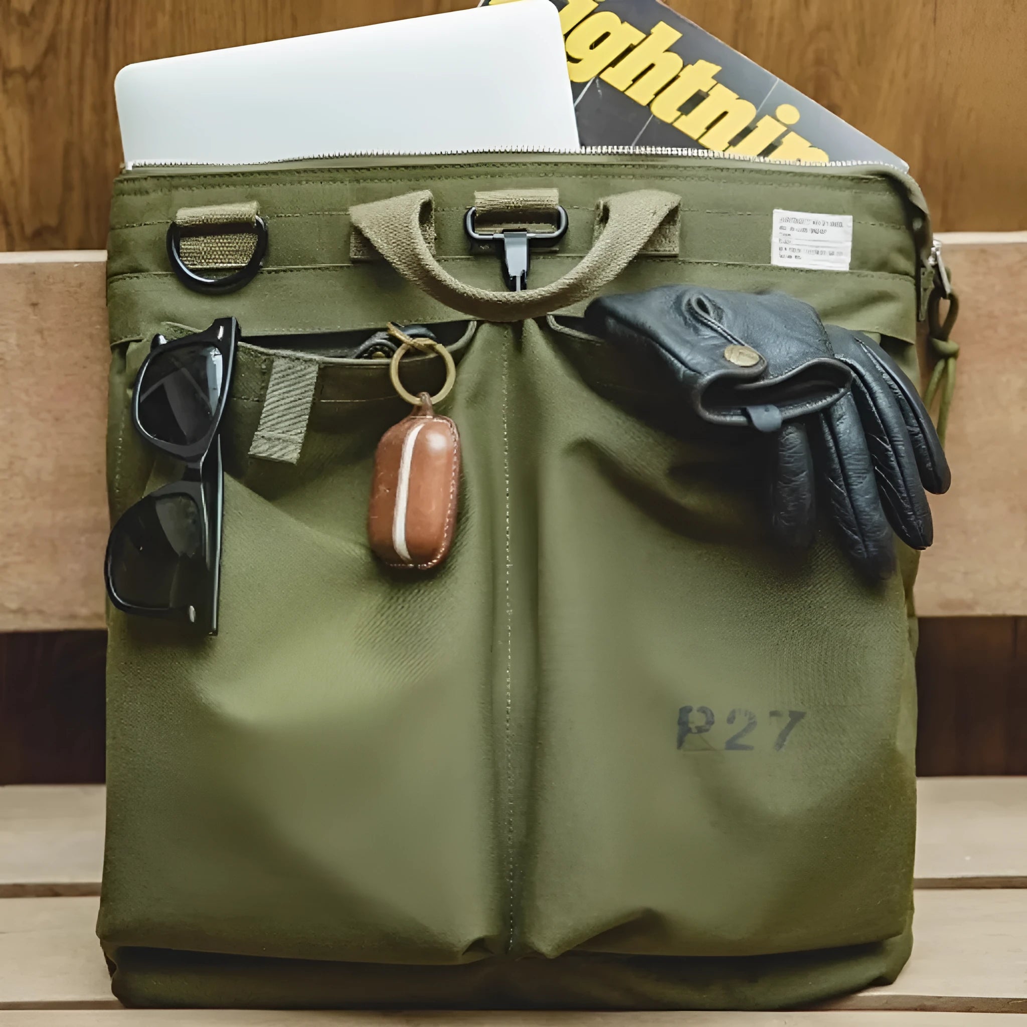 Military green canvas crossbody messenger bag with shoulder strap showing vertical square shape and zipper closure