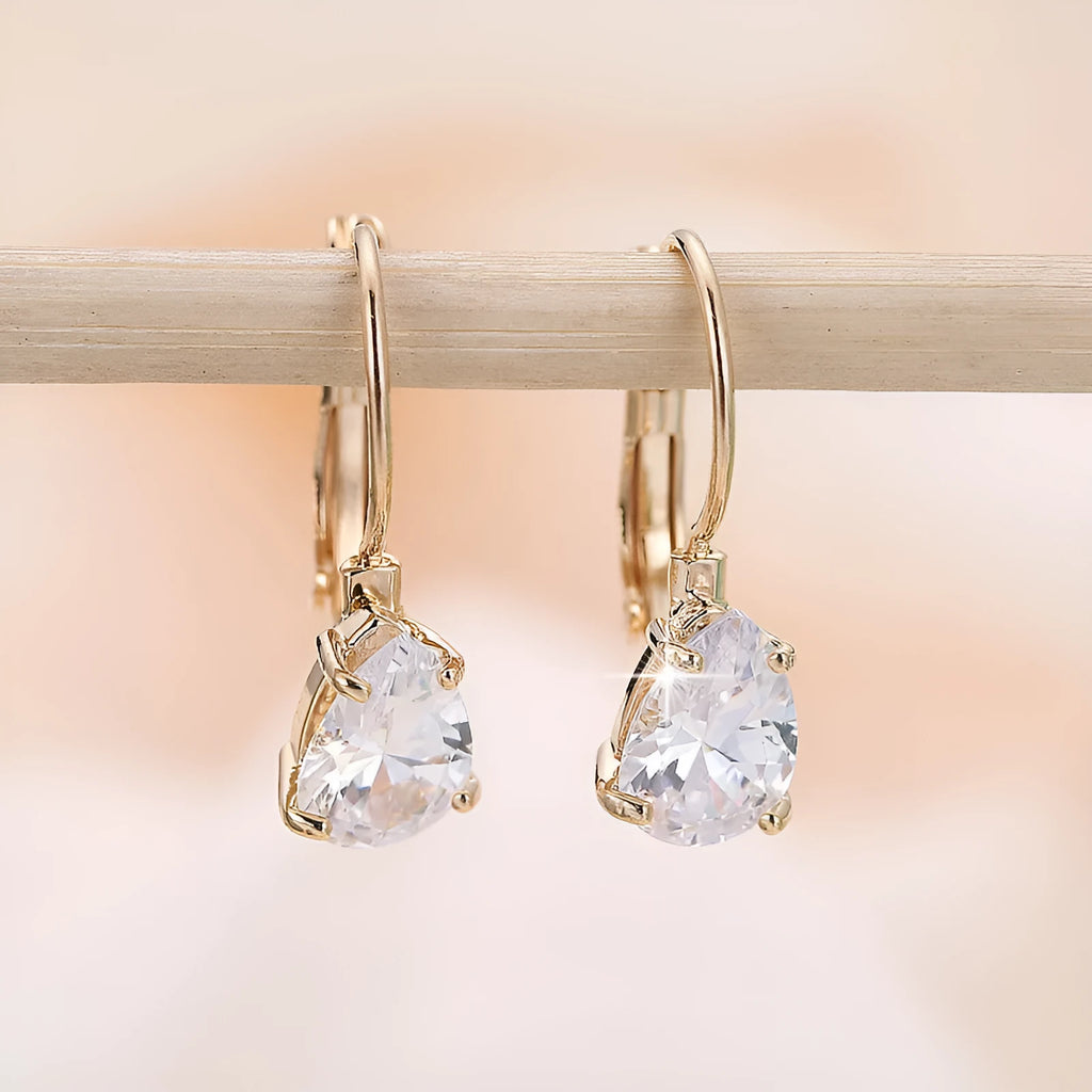 Gold and platinum drop earrings with a cubic zirconia stone set in a simple metal design.