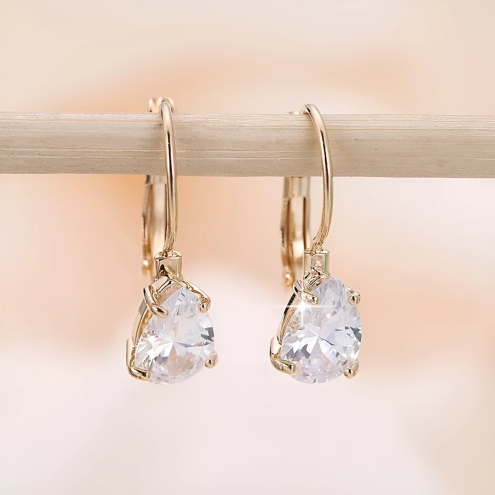 Gold and platinum drop earrings with a cubic zirconia stone set in a simple metal design.