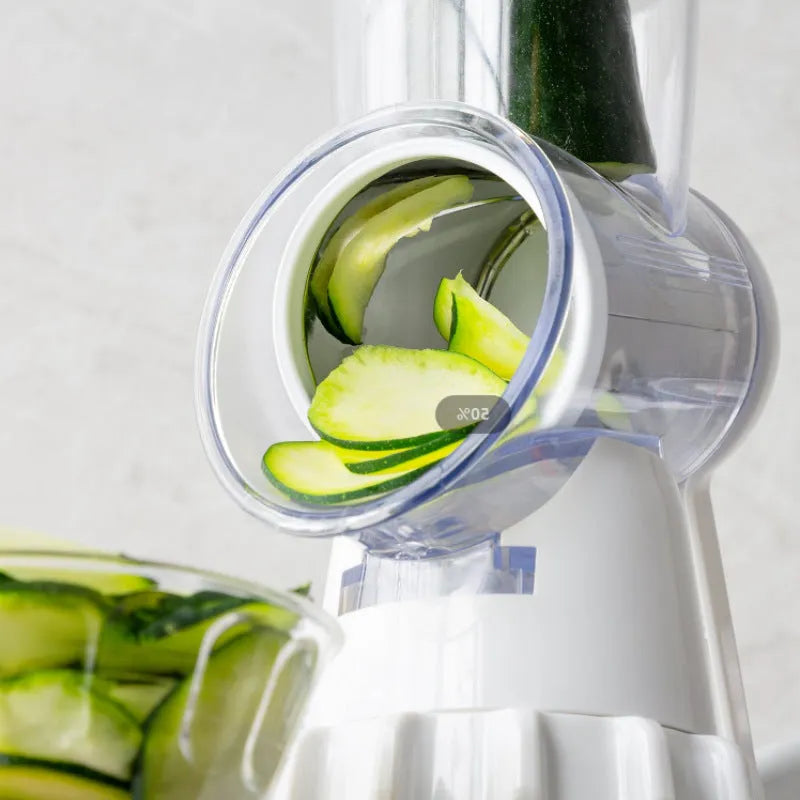 White manual vegetable slicer, grater, and chopper with three stainless steel blades and suction feet.