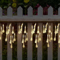 6.5 metre long solar-powered outdoor LED string lights with bubble drop pendants on a garden fence