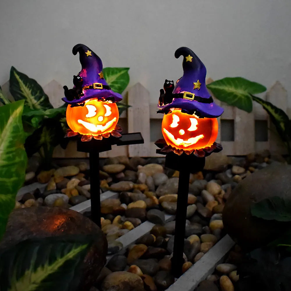 Solar Halloween pumpkin lantern with wizard pumpkin style on a garden path, wrought iron frame