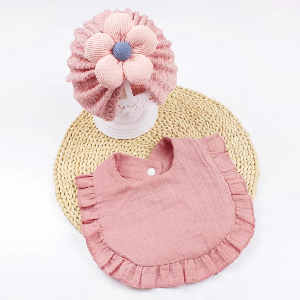 Newborn baby hat and bib set in organic cotton muslin with frilly lace trim