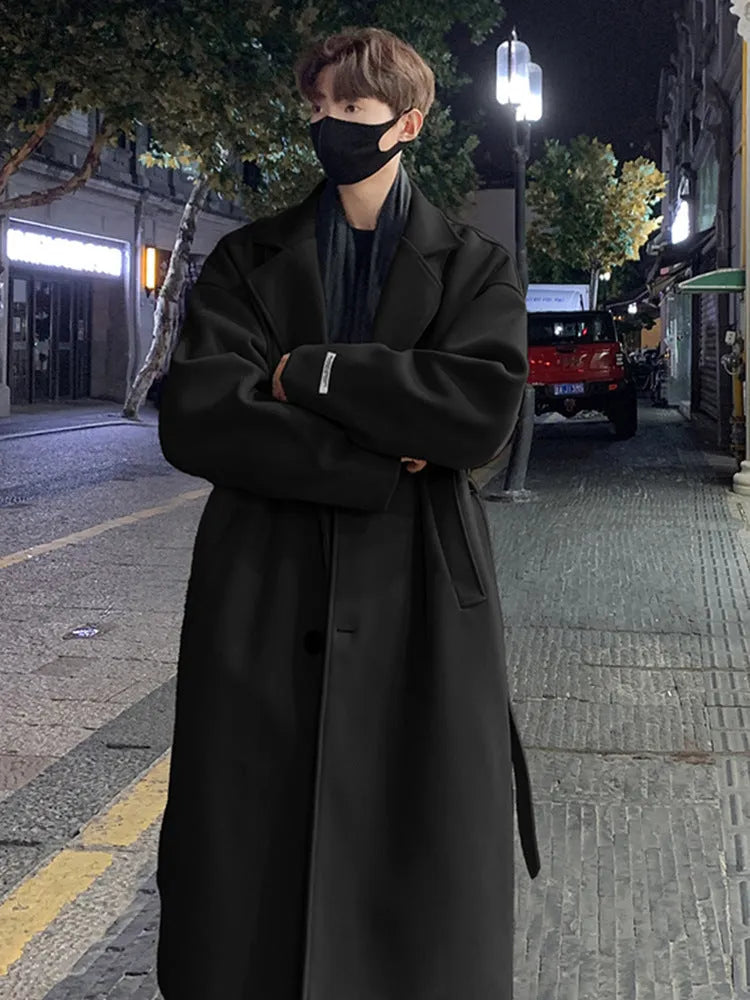 Men's British style mid-long wool coat in khaki with side seam pockets on a hanger