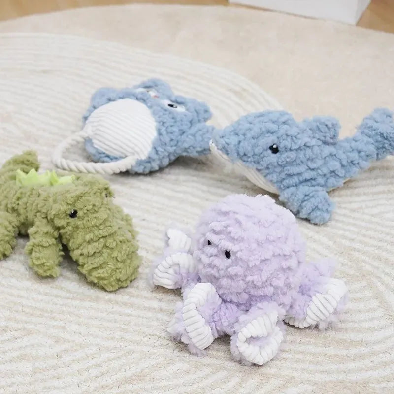 Plush corduroy caterpillar fabric dog toy in shark shape with squeaker on white background