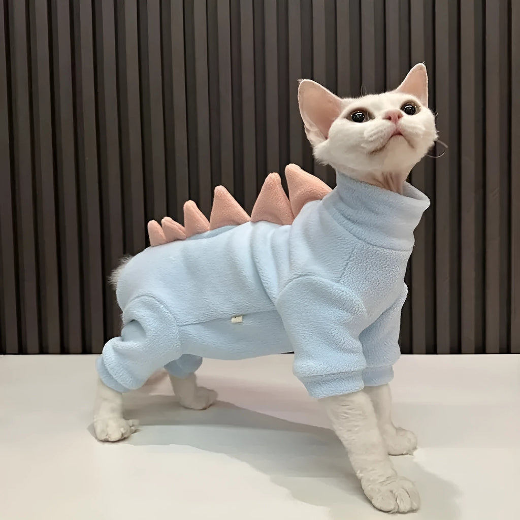 Sphynx cat wearing dinosaur costume with tail and back spikes, made from fleece material