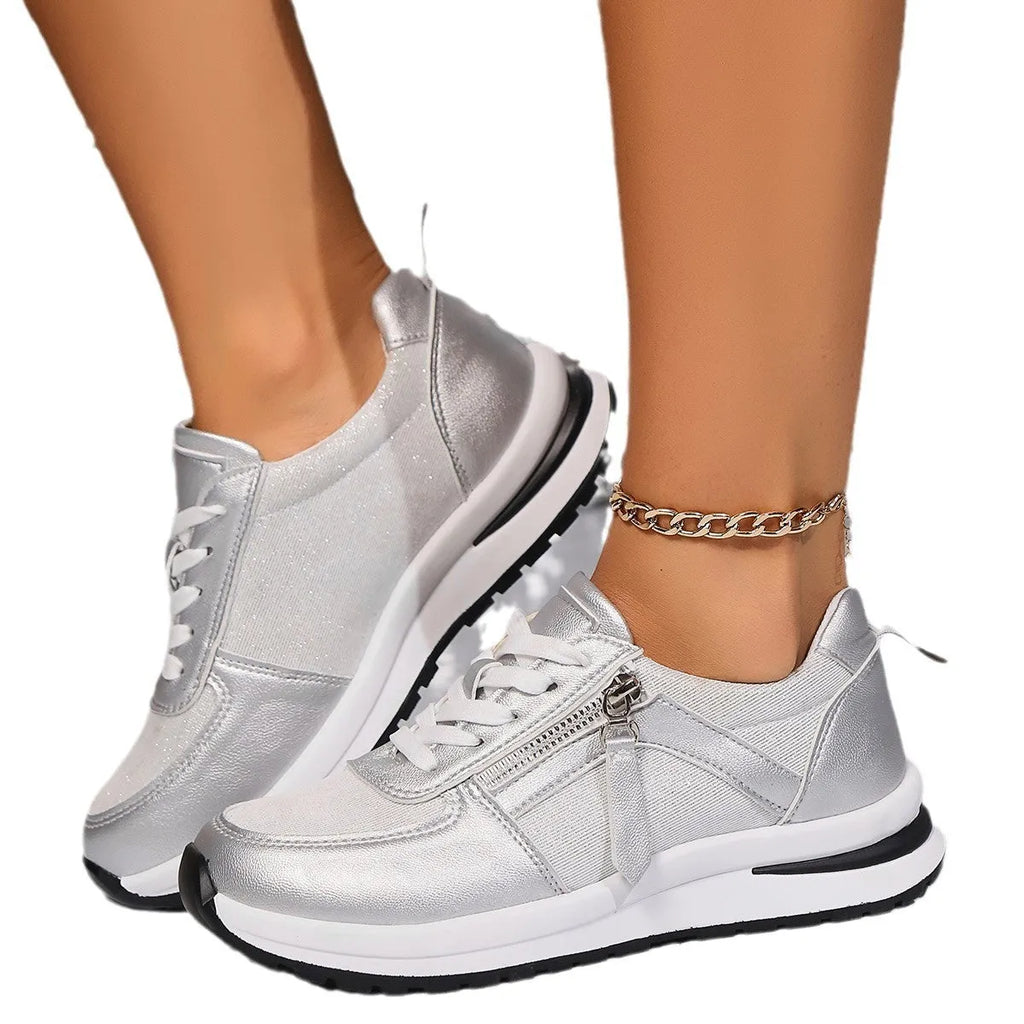 Gold women's flat lace-up pumps with round toe and rubber sole on a white background.