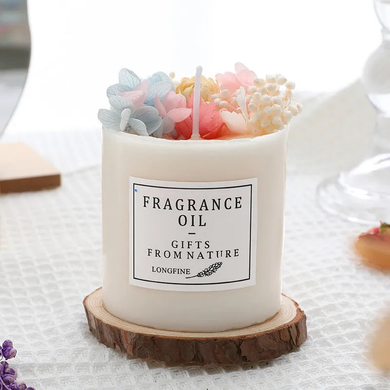 Decorative aromatherapy candle with dried flowers on surface, shown in gift box with chip base.