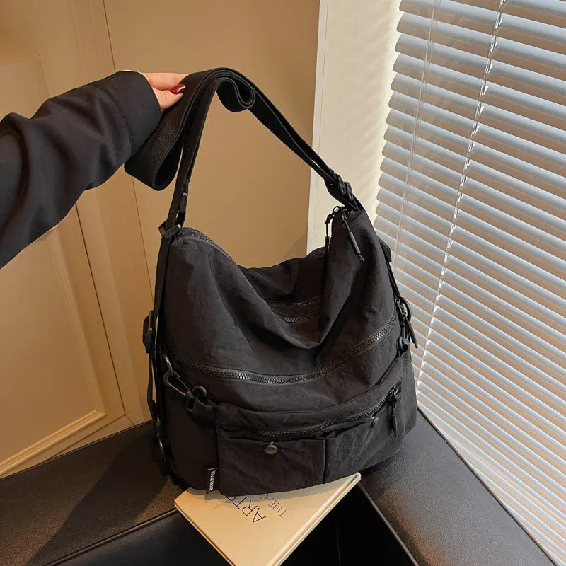 Women's nylon crossbody bag with double shoulder straps showing multiple pockets in black colour